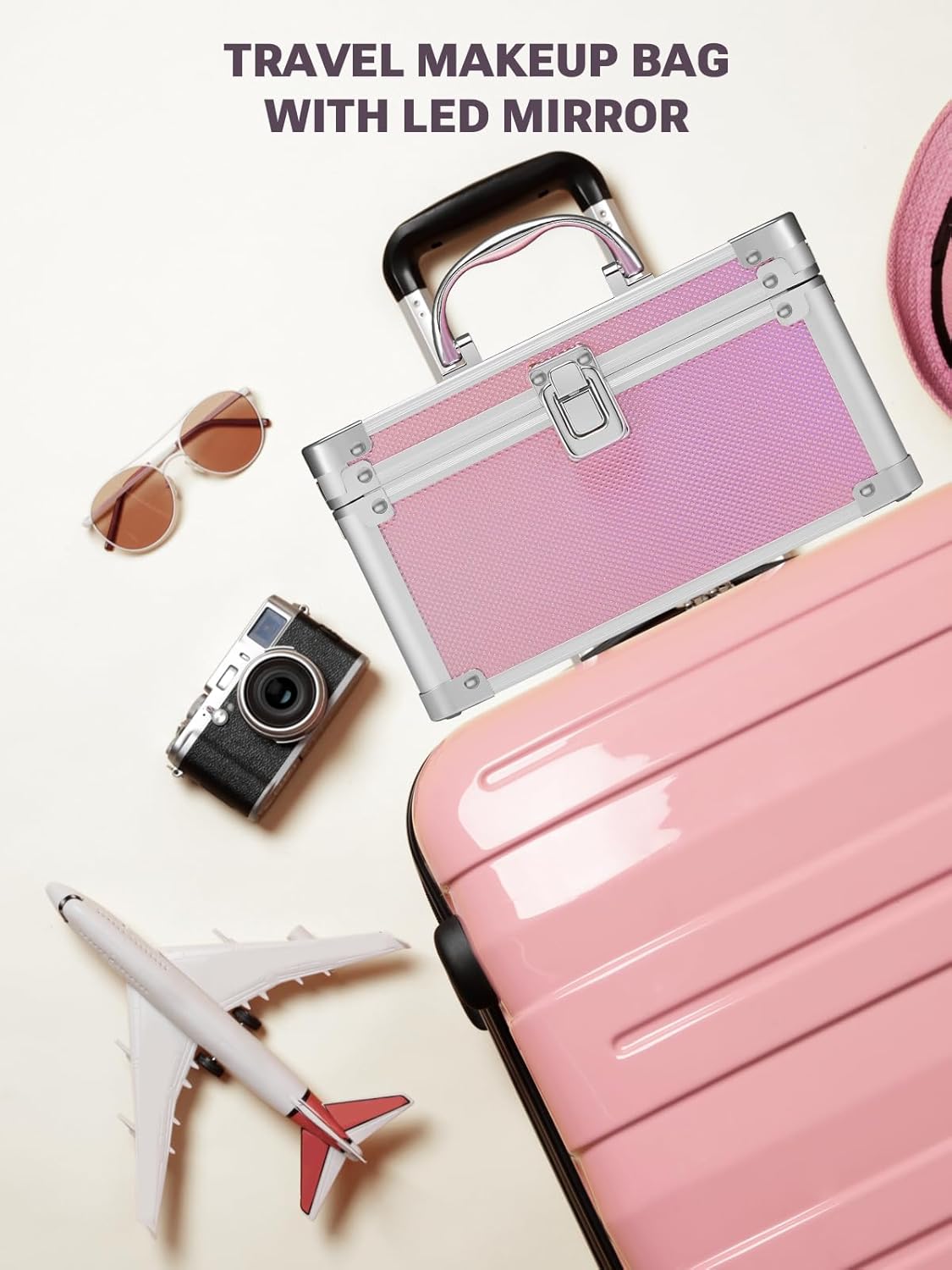 Pink travel makeup box with LED mirror, sunglasses, camera, and toy airplane on a light background