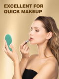 woman applying a lipstick while holding a green makeup round mirror