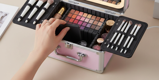 open Qislee professional makeup case. A hand is adjusting the modular EVA foam dividers, demonstrating how different sized cosmetics like flat palettes, tall bottles, and a professional brush set fit perfectly